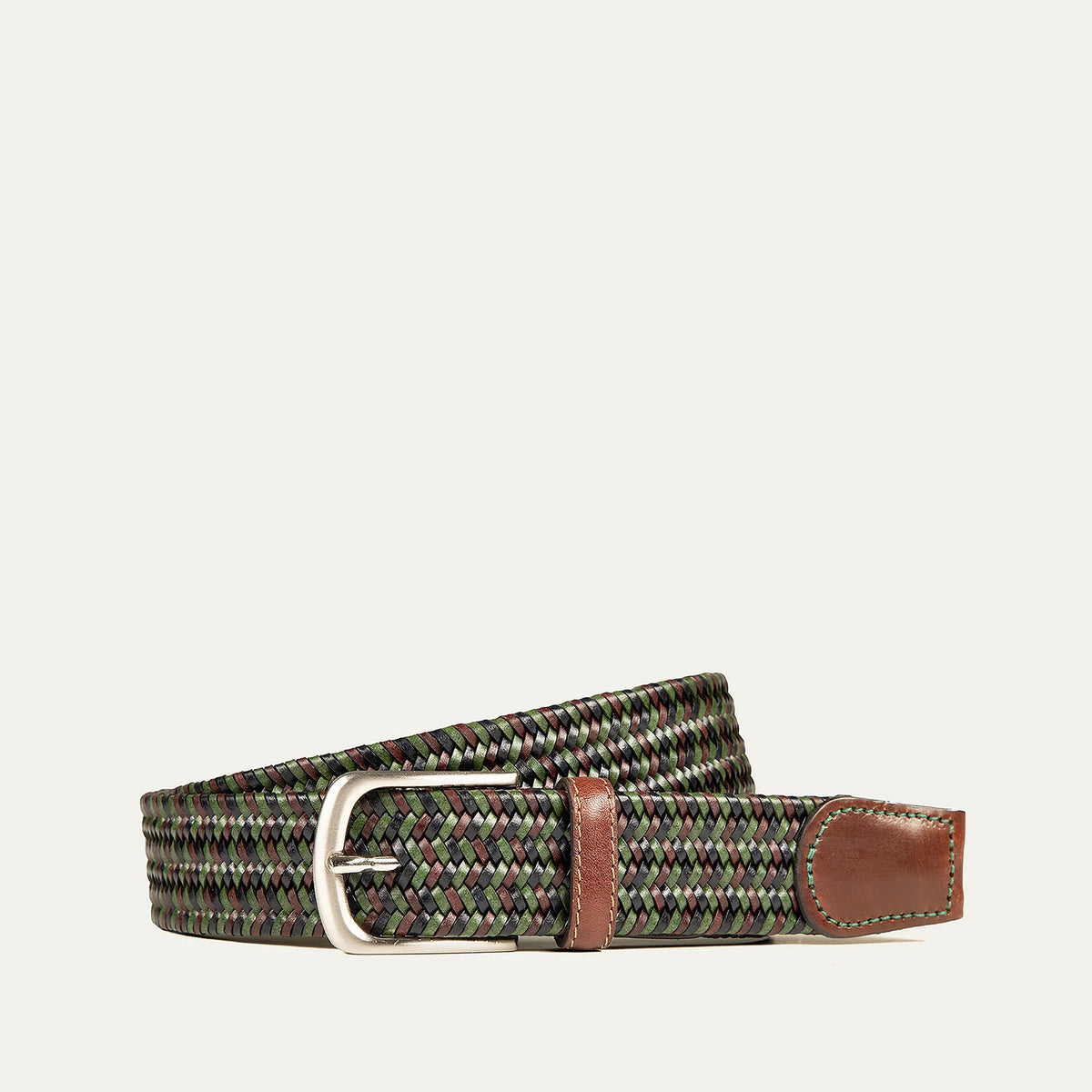 The WILL LEATHER GOODS - STRETCH BELT features a green, purple, and black braided design with full-grain leather accents by the silver buckle and tip, shown on a plain light background. Brand: WILL LEATHER GOODS.
