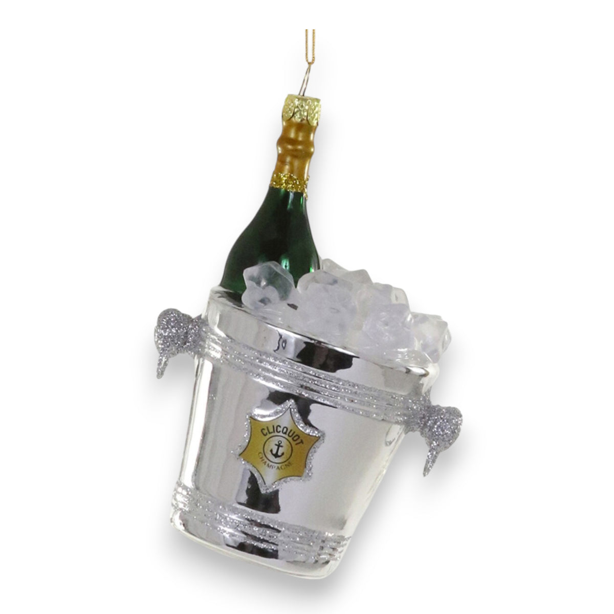 The CHAMPAGNE ON ICE ORNAMENT by CODY FOSTER is a glass decoration shaped like a silver ice bucket with a green champagne bottle, ice cubes, and a gold hanging string.