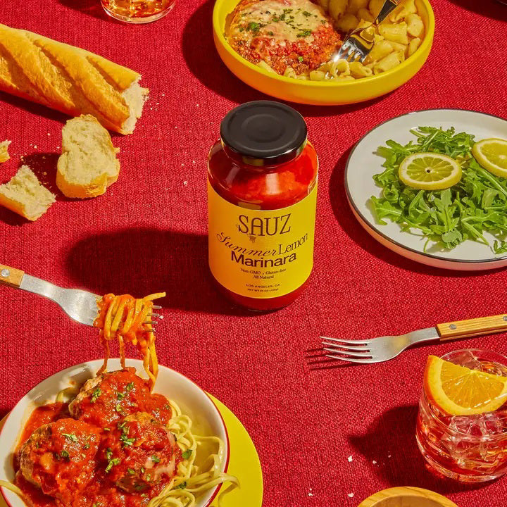 A jar of SAUZ Summer Lemon Marinara, featuring a vibrant yellow label with “Zesty Citrus Tomato Sauce,” showcases bold, savory flavors made from locally-sourced ingredients.