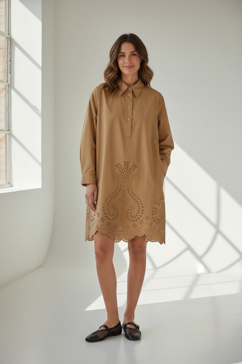 A person stands against a white background wearing the MEIMEIJ Lasercut Cotton Shirt Dress featuring eyelet embroidery and scalloped cuff hems, paired with black flat shoes.