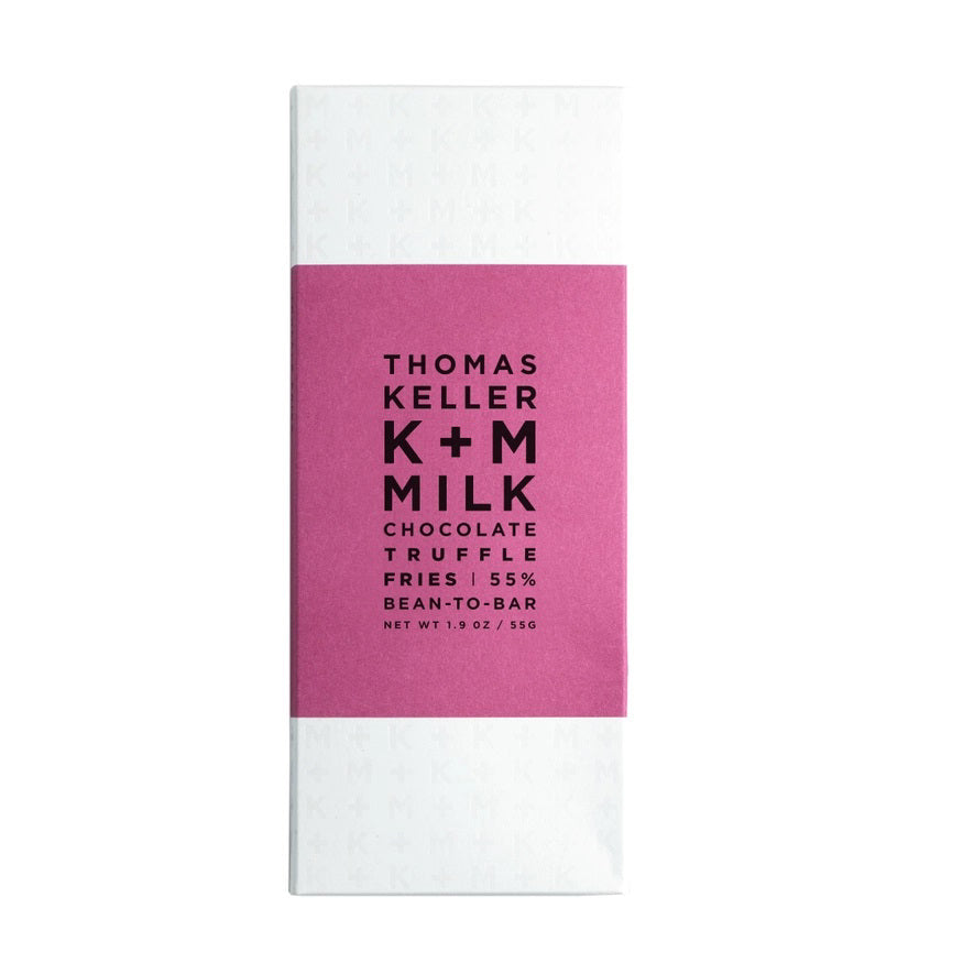 A white chocolate bar wrapper with a pink label in the middle. The label reads "K &amp; M EXTRAVIRGIN CHOCOLATE K+M MILK CHOCOLATE TRUFFLE FRIES 55% BEAN-TO-BAR MILK CHOCOLATE NET WT 1.9 OZ/55G." The background of the wrapper has faint "K+M" text repeatedly printed, highlighting.