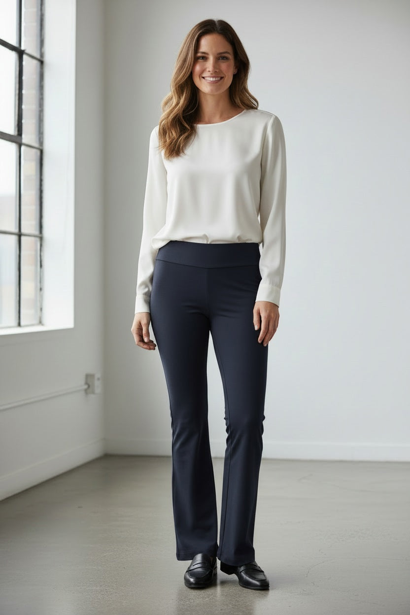 A person is showcased against a white background wearing KRAZY LARRY, INC's MICROFIBER PULL ON PANT - LONG in a high-waisted design paired with sleek black heeled sandals. Their top and arms are partially visible, contributing to an elegant silhouette.