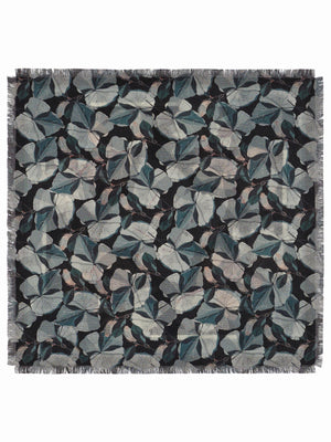 The FRANCO FERRARI - GRIDO REVERSIBLE WOOL SCARF 68X68 features a square shape, with blue, white, and mauve floral patterns on black, fringed edges, and detailed flowers and leaves at the corners and borders.