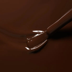 A bottle of MANUCURIST - GREEN™ Nail Polish in Clove by MANUCURIST INC, featuring a rich chocolate brown shade and a black cap. The label reads “green quick dry intense color.”.