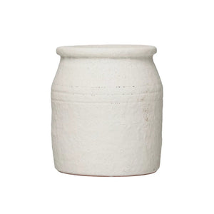 The DISTRESSED TERRACOTTA CROCK by CREATIVE COOP is a rustic, off-white earthenware pot with a cylindrical shape and slightly flared rim, featuring a textured finish. This charming piece adds timeless elegance to any home décor.