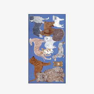 A person wears a sleeveless beige top and the INOUI EDITIONS - TOUTOU SCARF IN BLUE by INOUI, featuring a detailed animal print with white fur and brown accents, wrapped around their neck against a plain white background.