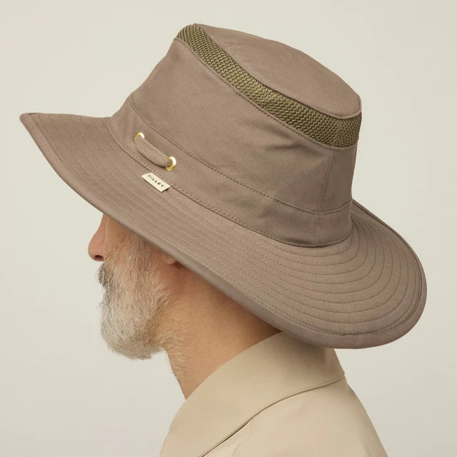 A man with a gray beard and mustache wears the TILLEY Airflo Hikers Hat T4MO-1 in olive, featuring UPF 50+ sun protection, and a beige button-up shirt, looking directly at the camera against a plain light background.