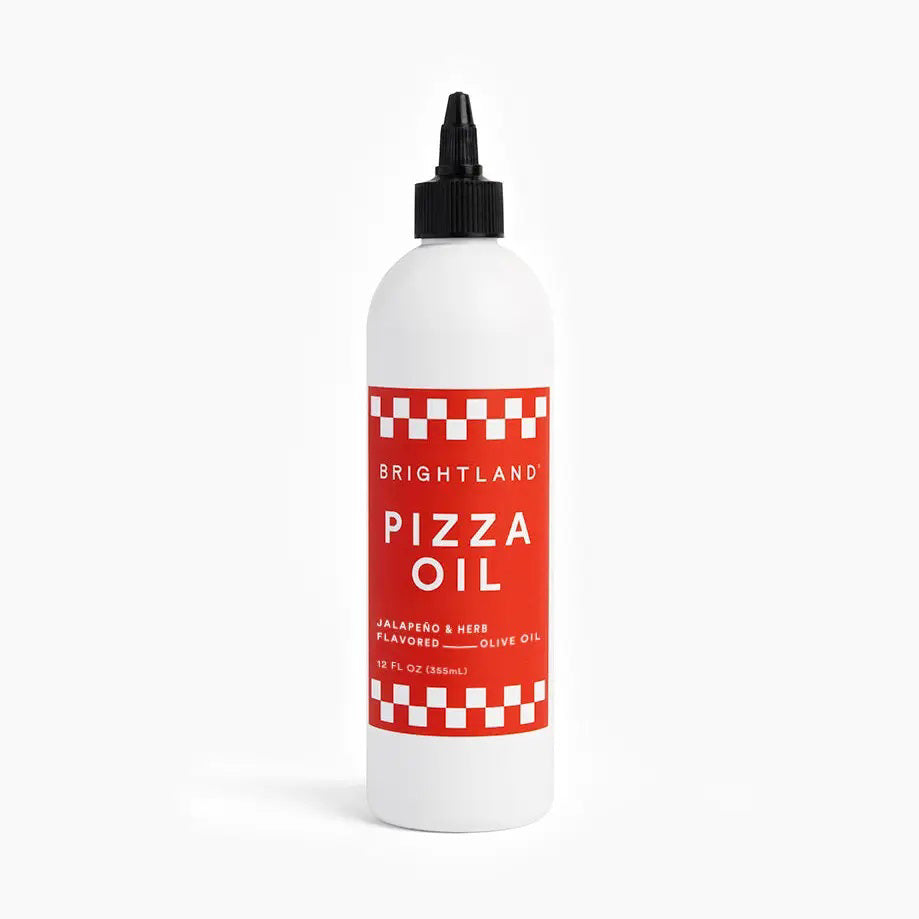 A white bottle features a red label that reads &quot;BRIGHTLAND - PIZZA OIL.&quot; The label emphasizes the &quot;Jalapeño &amp; Herb Flavored Olive Oil,&quot; highlighting an herbaceous essence. The bottle has a black cap and is displayed against a plain white background.