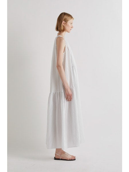 A person stands against a plain white background, wearing the MEIMEIJ Sleeveless Maxi Dress with Stripes, an ankle-length summer piece styled with flat sandals and a statement necklace for an effortlessly chic look.