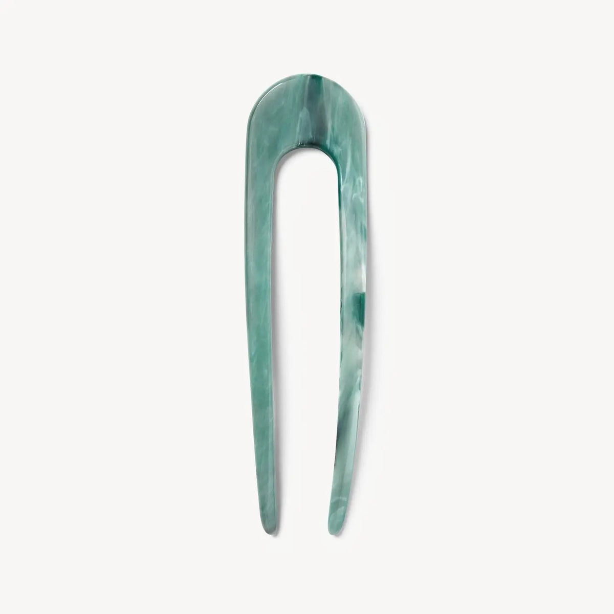 The MACHETE - FRENCH HAIR PIN IN JADEITE is a handcrafted green marbled two-prong hair fork made from Italian acetate, with a rounded top, shown vertically against a white background.