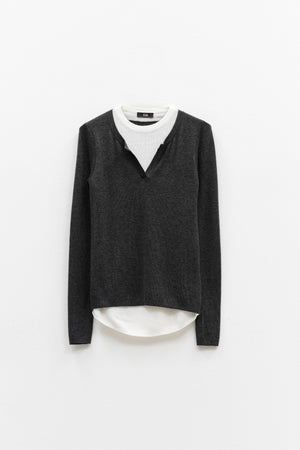 The ELEH - SWEATER WITH BUILT IN T-SHIRT features a charcoal gray sweater with a V-notch neckline layered over an attached white round-neck shirt, both displayed against a plain white background.