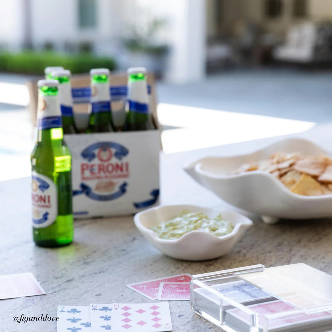 The BEATRIZ BALL - VIDA NUBE BOWL WITH DIP features two white, organically-shaped ceramic platters with wavy edges, nested together like petals or waves. They rest elegantly against a plain white backdrop, reminiscent of the sophisticated VIDA Nube collection by Beatriz Ball.