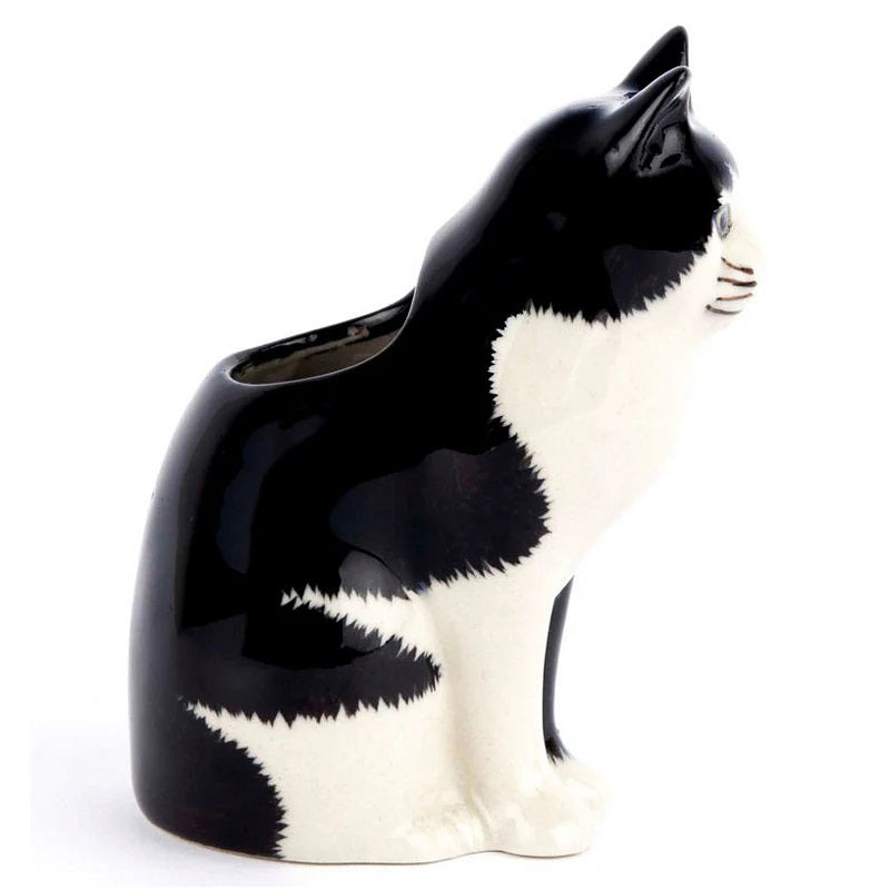 The QUAIL CERAMICS - BARNEY BUD VASE by QUAIL DESIGNS is a hand-painted black and white ceramic cat vase, shown with pink, white, and purple flowers including lavender, set against a plain white background.