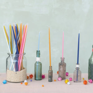 The CREATIVE COOP UNSCENTED THIN TAPER CANDLES IN NAVY are displayed in an open box containing 36 neatly arranged candles, with several matching navy candles laid side by side on a white background.