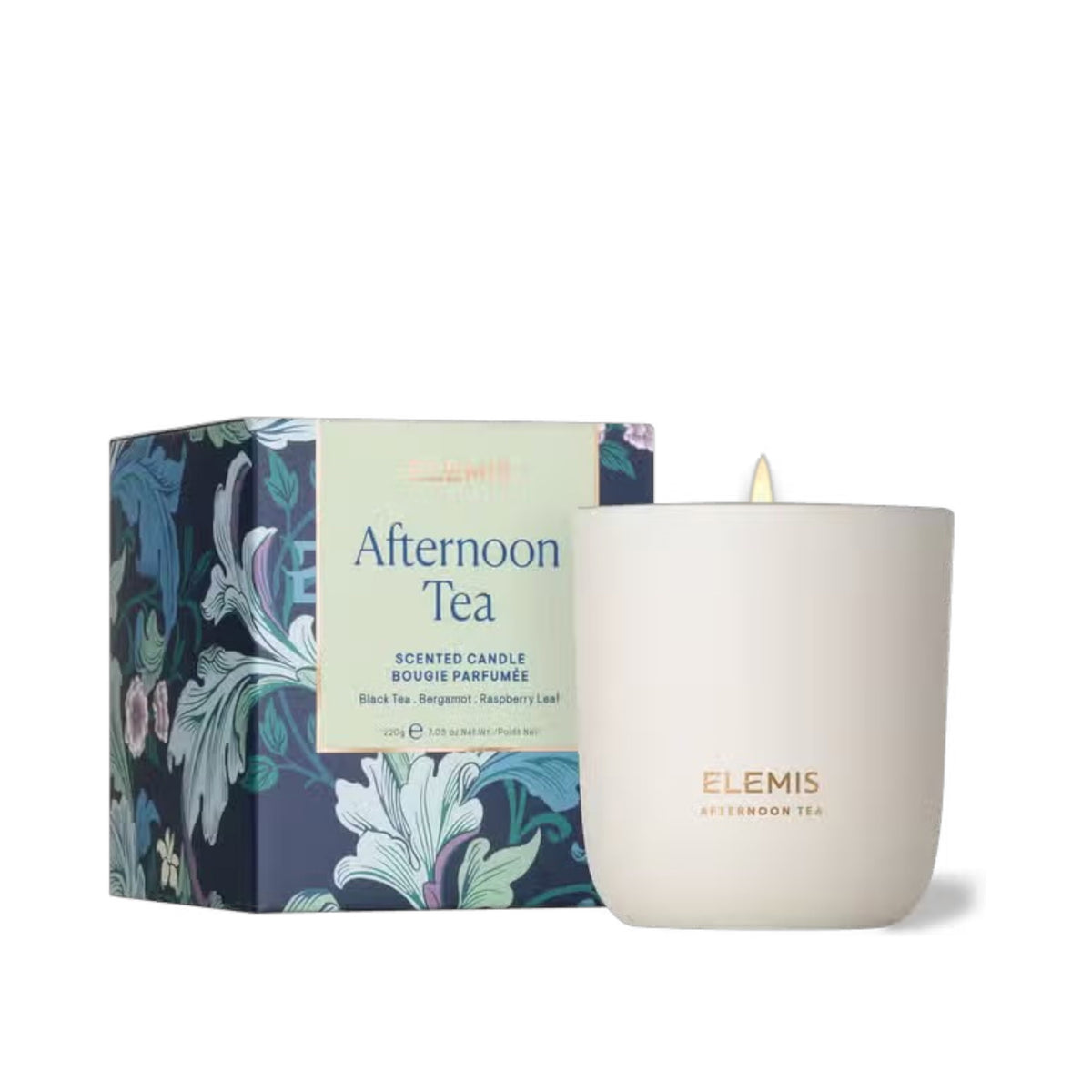 A lit ELEMIS - AFTERNOON TEA CANDLE by ELEMIS - STEINER sits in a white cup with the label &quot;Elemis Afternoon Tea,&quot; complemented by a decorative box featuring floral designs and descriptions. The candle&#39;s scents include Black Tea, Bergamot, and Raspberry Leaf, all crafted from premium mineral wax.