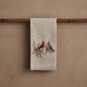 A CORAL & TUSK CHRISTMAS CARDINALS LINEN TEA TOWEL made of embroidered natural flax fiber featuring two cardinals perched on pine branches with berries.