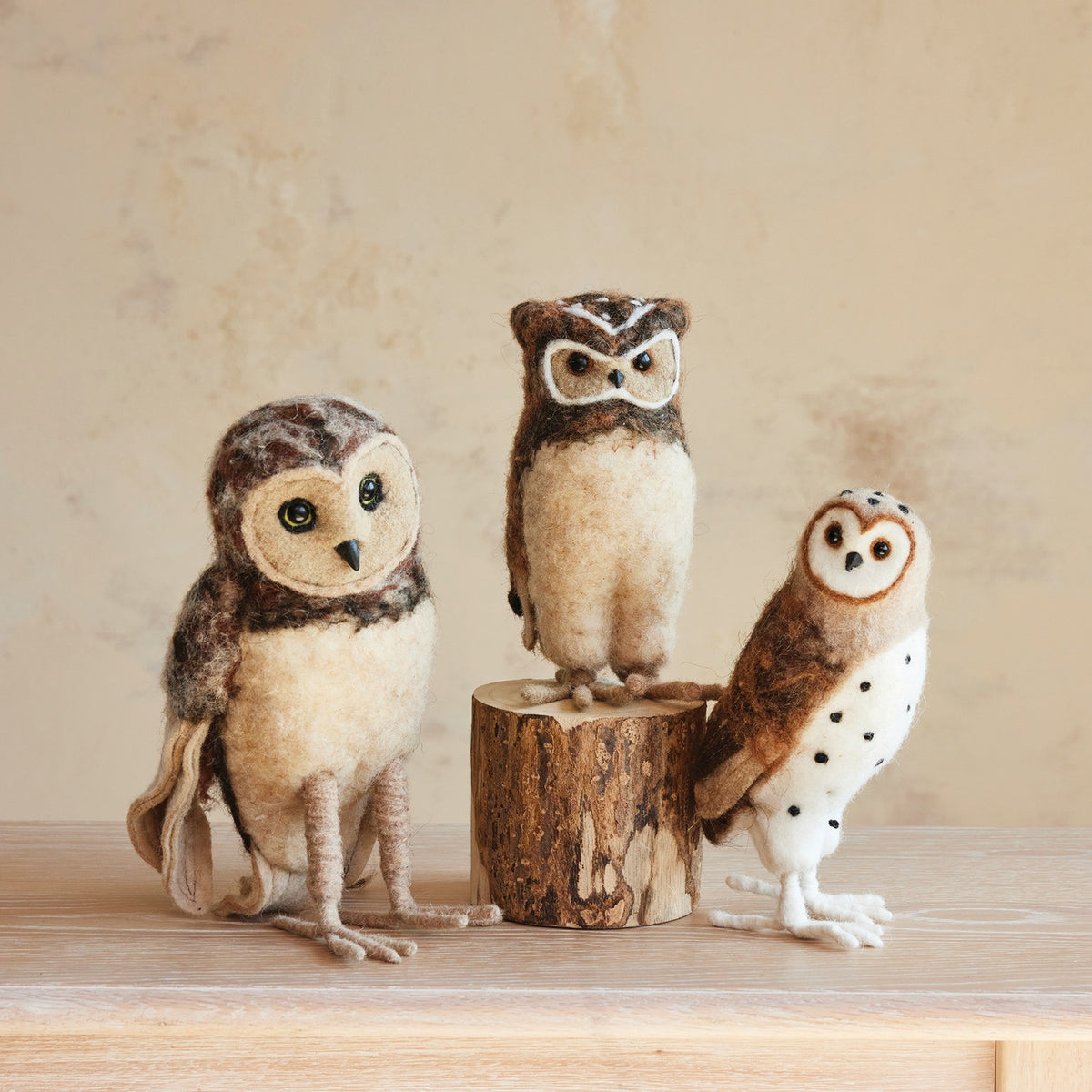 Three HANDMADE WOOL FELT BARN OWL, BROWN figures of varying sizes displayed on a wooden surface as festive Christmas decor.