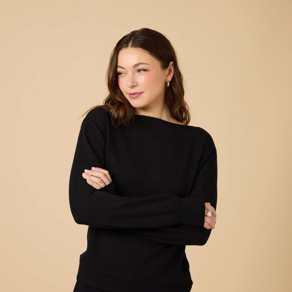A woman wears a SOFTIES - DREAMTECH BOAT NECK WITH PINTUCK PANT SET in olive green, featuring a long-sleeve boat neck top and matching wide-leg pintuck pants.