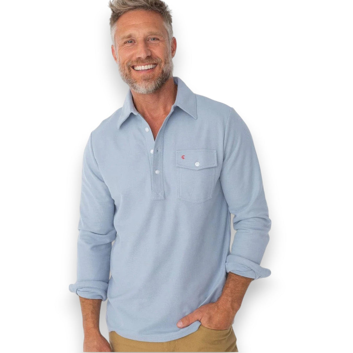 A smiling man with short blond hair and a beard wears the CRIQUET Long Sleeve Players Polo Shirt in Mr Freeze, standing against a plain white background.