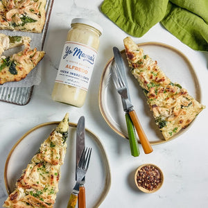 YO MAMA'S - CLASSIC ALFREDO by YO MAMA'S FOODS is a premium sauce made with fresh cream and parmesan, labeled gluten-free, no sugar added, and crafted with fresh ingredients. The jar has a white label with navy and orange text.