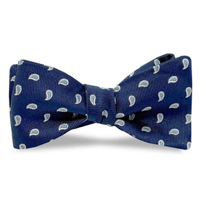 The BIRD DOG BAY PETER-BLAIR Cape Cod Silk Bow Tie in Navy features a white paisley pattern and comes unfastened for easy adjustment, offering elegance and comfort against a classic white background.