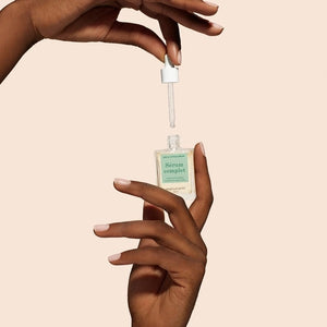 A square glass bottle labeled “MANUCURIST - COMPLETE SERUM” by MANUCURIST INC is displayed, featuring a dropper cap. The dropper, filled with a clear liquid dotted with tiny bubbles, rests beside the bottle—ideal for nourishing damaged nails and delivering essential hydration to cuticles. The scene is set against a soft beige background.