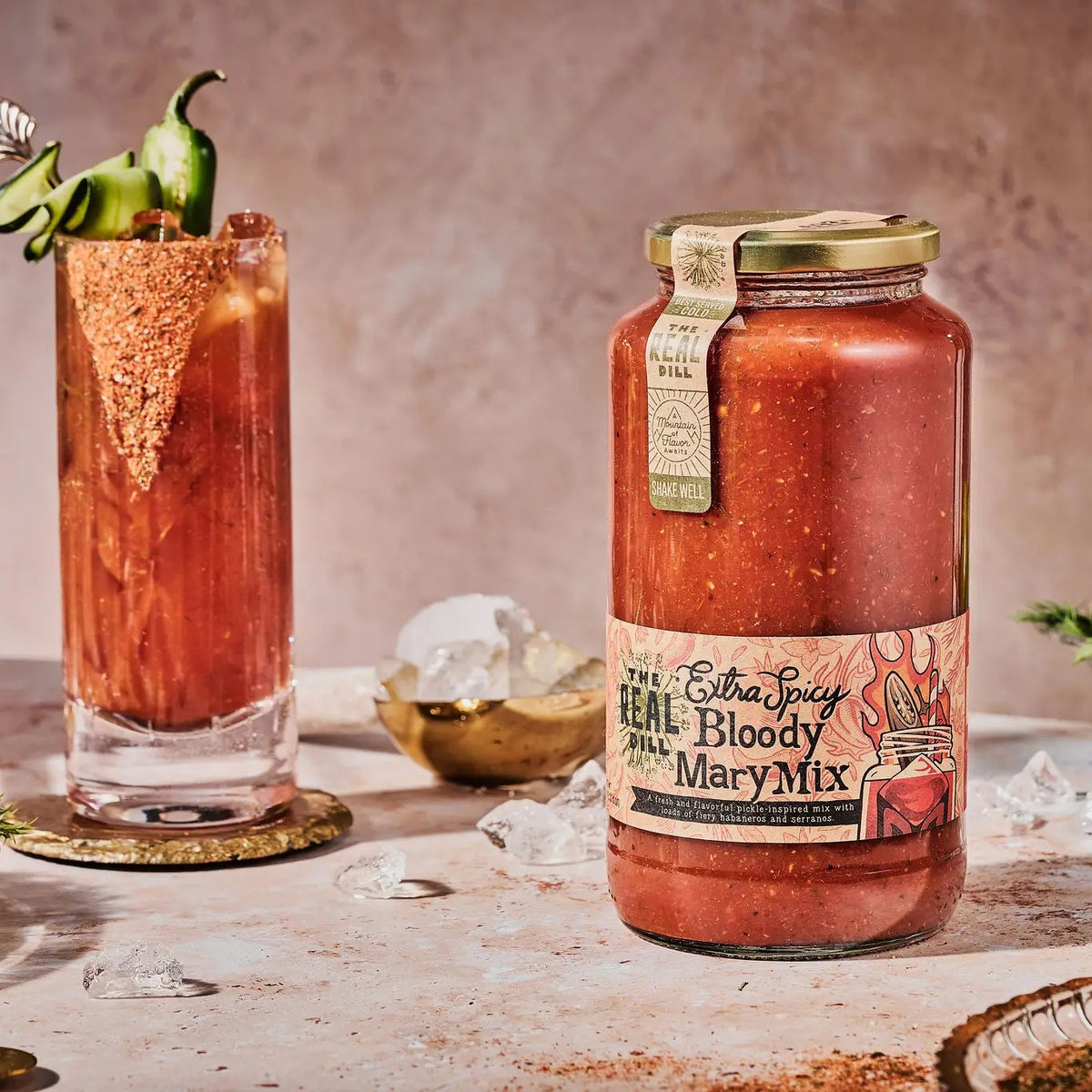 A 32oz jar of THE REAL DILL - EXTRA SPICY BLOODY MARY MIX, a bold and spicy dill pickle bloody mary mixer from THE REAL DILL, featuring an illustrated label with a cocktail and filled with thick orange-red liquid—perfect for spice lovers seeking the ultimate cocktail mixer.