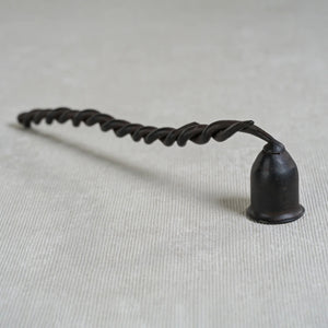 The ZODAX TWISTED WROUGHT IRON CANDLE SNUFFER features a black, spiral handle and a small, cup-shaped snuffer at one end, shown isolated on a white background.