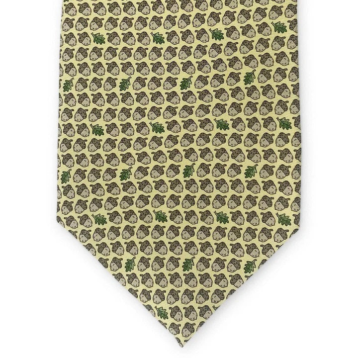 The PETER-BLAIR - ACORNS SILK TIE IN YELLOW by BIRD DOG BAY is a handmade yellow necktie from New York, adorned with a repeating pattern of brown acorns and occasional green oak leaves.