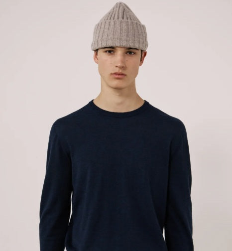 A nut-colored ribbed beanie by HARTFORD, expertly crafted from a soft cashmere and wool blend, featuring a folded cuff and shown against a plain white background, exuding luxurious knitwear appeal.