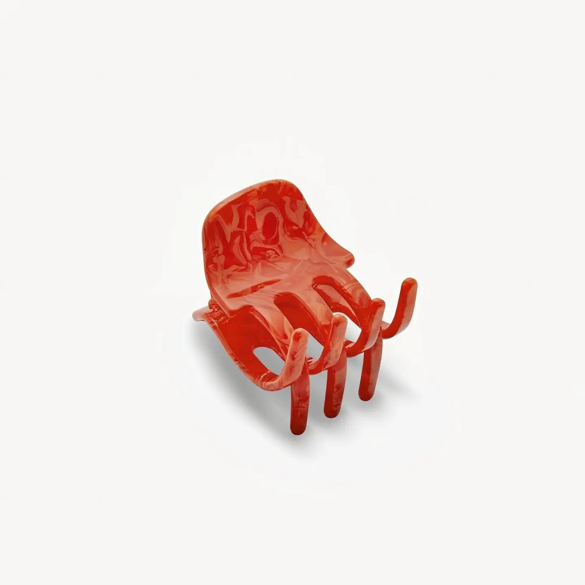 The MACHETE - MINI HAIR CLAW IN POPPY, a handcrafted marbled red claw clip with three prongs, made from Italian acetate, is displayed on a plain white background.
