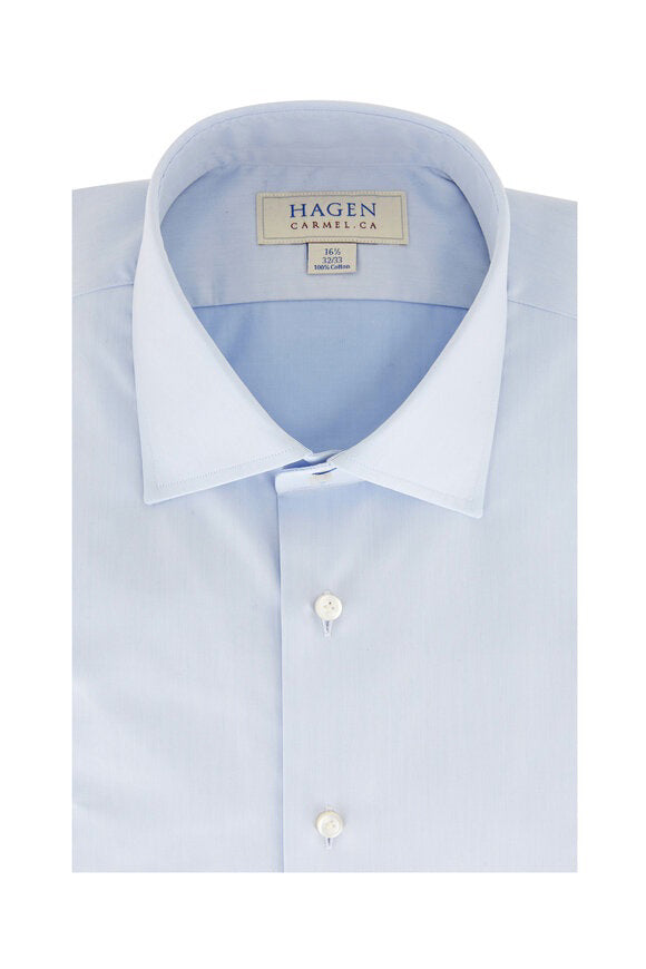 The HAGEN - COTTON DRESS SHIRT IN LIGHT BLUE is neatly folded, featuring a modern spread collar, white buttons, and premium cotton. The label inside the collar displays "Hagen Carmel, CA" with size details.