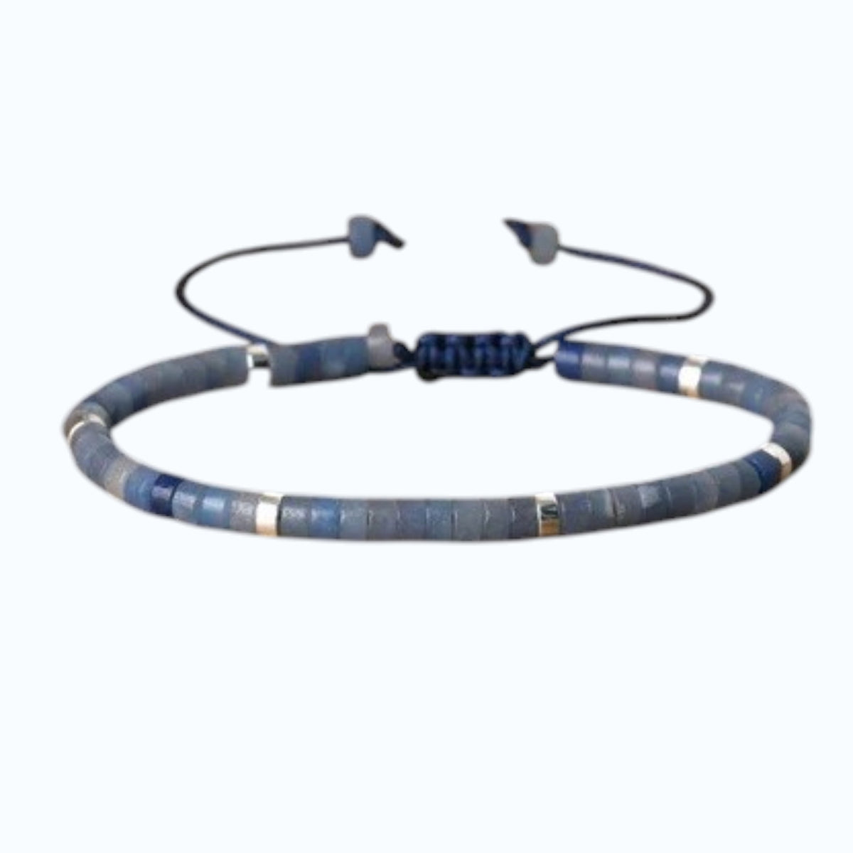 The STOLEN RICHES Ibiza Bracelet in Aventurine Heishi Stone features minimalist flat green beads with metallic accents on an adjustable dark cord, adding a perfect bohemian touch to your style.