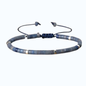 The STOLEN RICHES Ibiza Bracelet in Aventurine Heishi Stone features minimalist flat green beads with metallic accents on an adjustable dark cord, adding a perfect bohemian touch to your style.