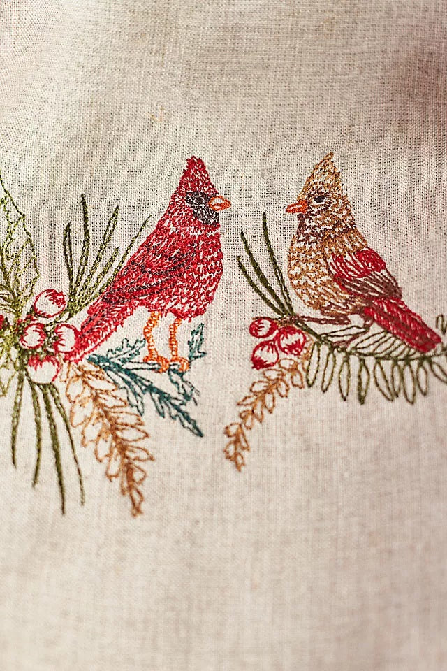 A CORAL & TUSK CHRISTMAS CARDINALS LINEN TEA TOWEL made of embroidered natural flax fiber featuring two cardinals perched on pine branches with berries.