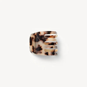 The MACHETE Mini Hair Claw in Ash Blonde Tortoise is crafted from Italian acetate with a brown, black, and cream tortoiseshell pattern—a timeless accessory displayed on a plain white background.