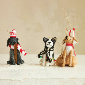 The CREATIVE COOP HANDMADE FELT DOG ORNAMENT set includes a brown dog with red scarf and present, a black dog in a red hat with bone, and a white cat with festive lights—all with strings for easy Christmas tree hanging.