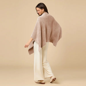 A woman wearing a black SOFTIES - SOLID RIB MARSHMALLOW SHAWL over a grey top and white trousers.