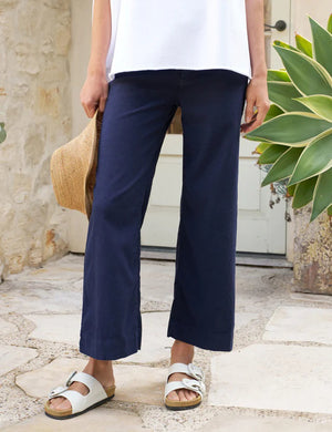 The FRANK & EILEEN Wexford Wide Leg Linen Pant in Navy is showcased against a light textured background. These high-rise trousers, crafted from Italian Performance Linen, feature a flat front and straight hem with a clean and minimalist design, absent of visible pockets or embellishments.