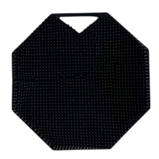 The SILICONE BODY AND EXFOLIATION BRUSH IN ONYX from SMILE BOUTIQUES features a black, octagonal silicone design with a textured, raised dot surface and a small triangular handle cutout at the top—perfect for use as a reusable shower brush or exfoliating body scrubber.