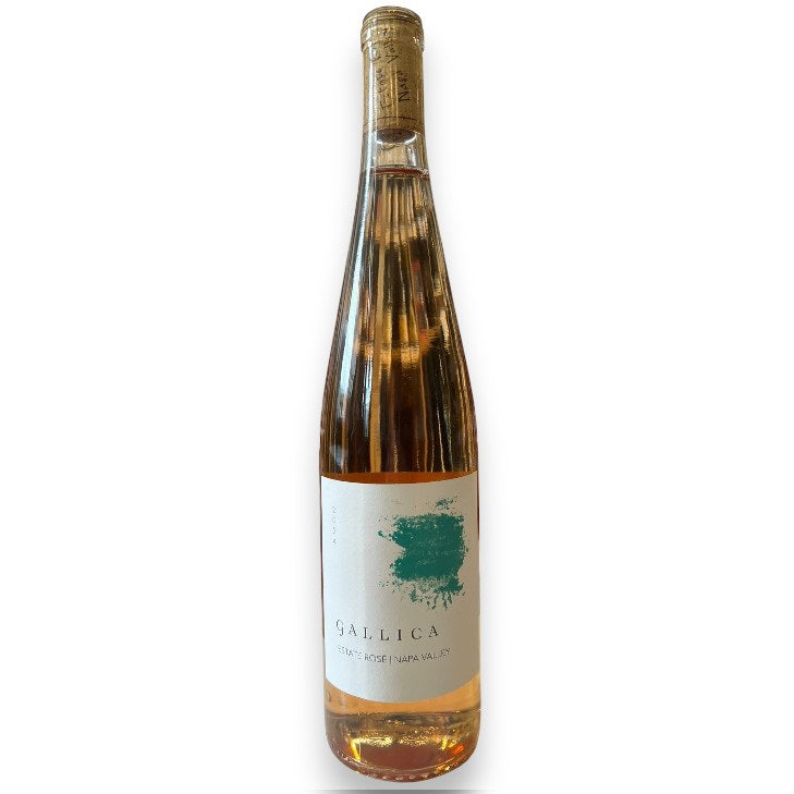 A tall, clear bottle of GALLICA ESTATE ROSÉ 2024 by WINE: JOHNSON BROS./OXFORD ST. gleams golden-pink with a white label and teal splash, topped by cork and gold foil, highlighting the wine’s refined style.