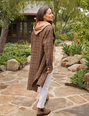 The Gavin Italian Boucle Shirt Jacket from Frank & Eileen is a long, plaid coat in shades of brown with an oversized fit. Made from luxurious pre-washed wool, the coat features a collared neckline, button closure, and two large front pockets. Sleeves are rolled to mid-length and the fabric showcases a textural, woven appearance. The tag inside reads "Frank & Ellen.