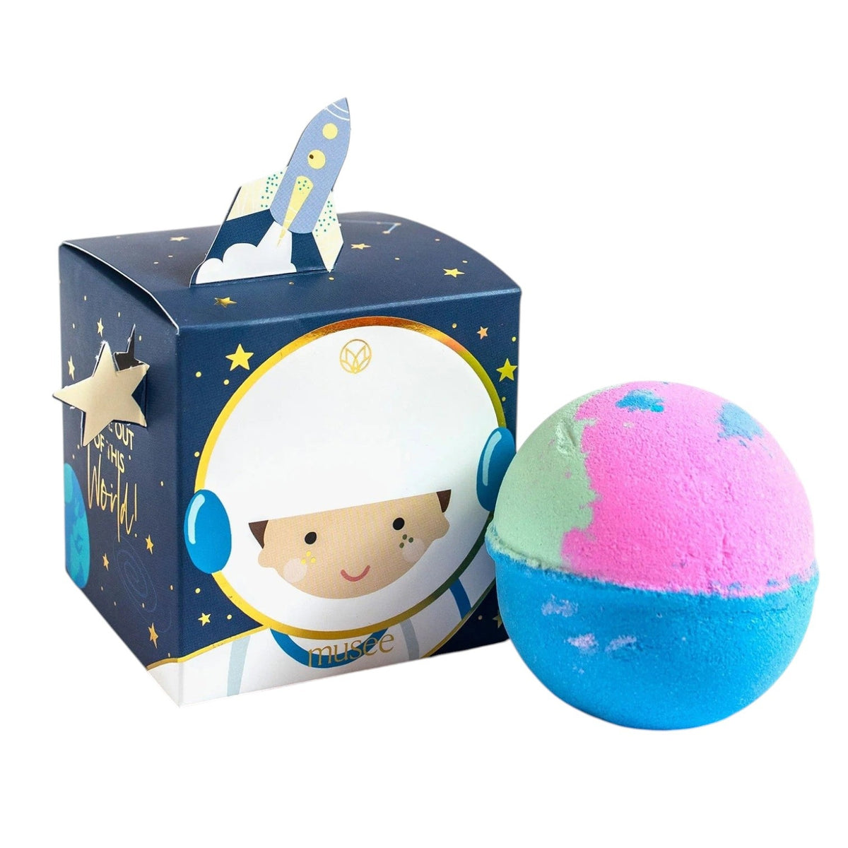 The MUSEE - YOU’RE OUT OF THIS WORLD BATH BALM from MUSEE rests next to its vibrant space-themed box, which features a smiling cartoon astronaut and a rocket on top, highlighting the playful appeal of natural bath products.