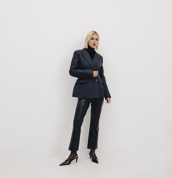 The MAC JEANS - AIDA KICK from the brand MAC are sleek, black faux leather pants designed for an excellent fit. They feature a button closure, two side pockets, and a slightly flared cut, all crafted from light vegan leather to provide a stylish and edgy look.