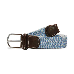 The ROOSTAS - SARASOTA WOVEN STRETCH BELT by ROOSTAS features sky blue and white weaving, brown leather ends, and a silver buckle, shown coiled with the buckle at the front.