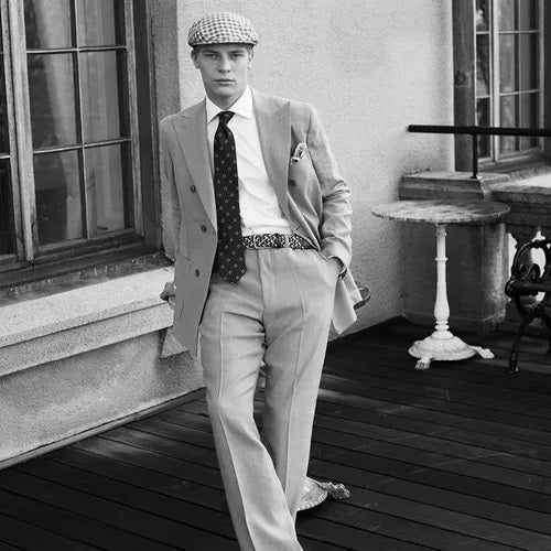 The WIGENS - Signature Woven Belt in beige, brown, and blues features an interlaced design with a silver buckle and dark blue leather ends.