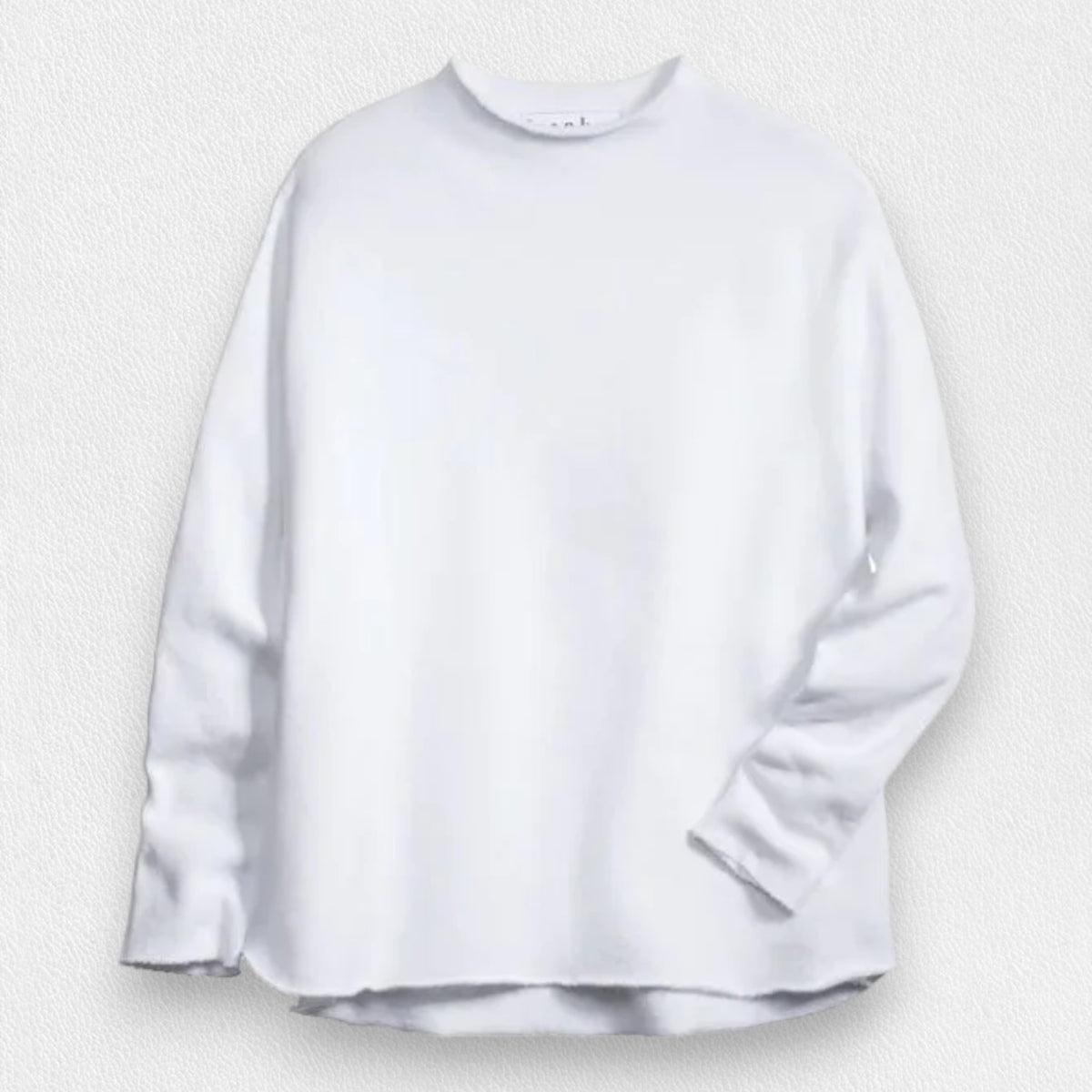 A woman with long brown hair stands smiling near a black grand piano in a modern, well-lit room. She wears the FRANK AND EILEEN - EFFIE LONG SLEEVE FUNNEL NECK CAPELET from FRANK &amp; EILEEN paired with blue jeans. A large window and a lamp are in the background, enhancing the cozy winter warmth of her stylish ensemble.