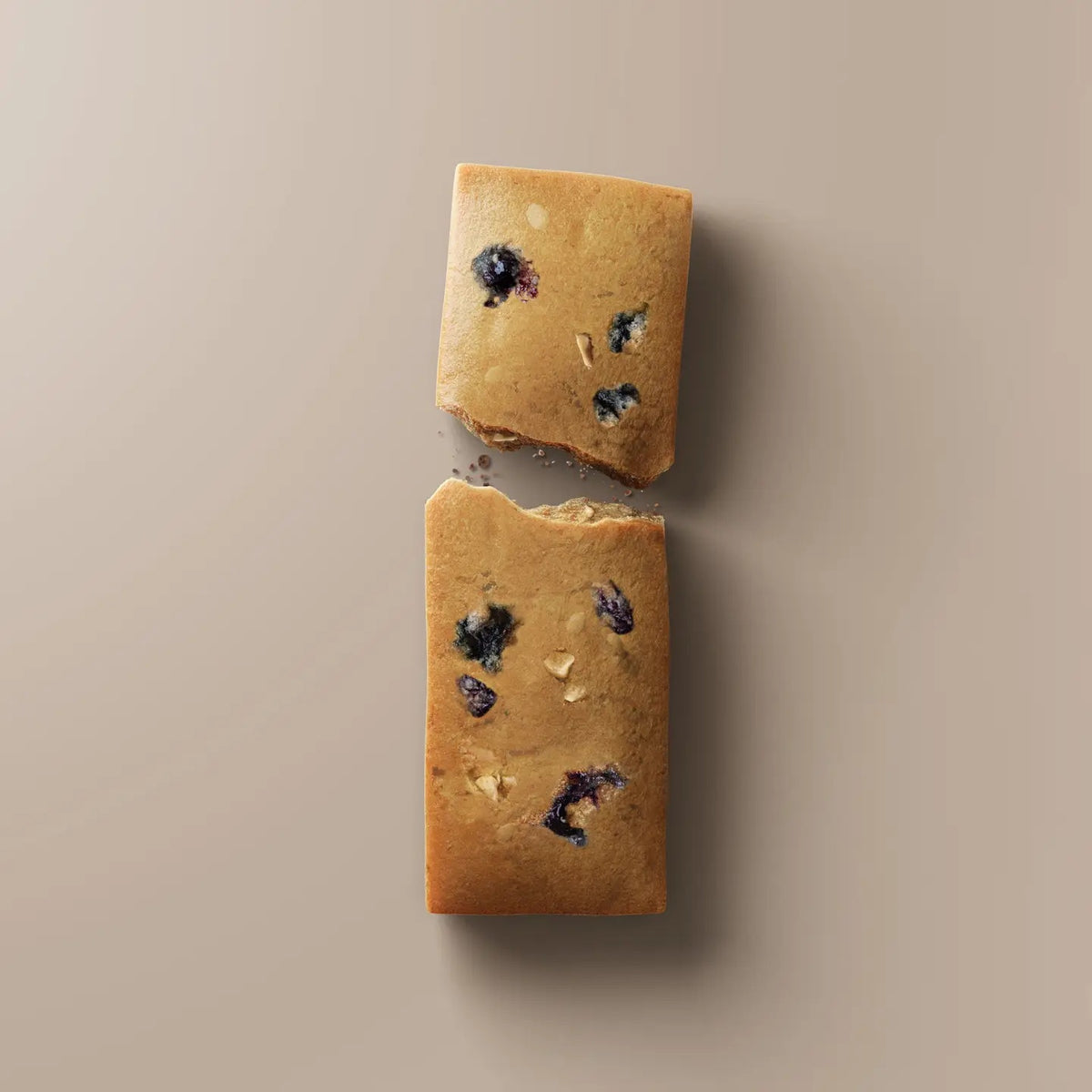 A purple STARS+HONEY - PEANUT BUTTER BLACKBERRY protein bar rests on a beige surface, with its wrapper highlighting 10g collagen, 15g protein, and 2g sugar.