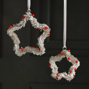 Two BEADED STAR ORNAMENT SILVER WITH RED BERRIES 4″ ornaments made of silver tubes and red beads, displayed on an iron glass coaster and hanging from white ribbons.