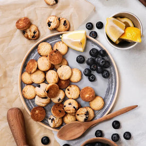 A box of MEMAWS COUNTRY KITCHEN - BLUEBERRY SHORTBREAD by 1 IN 6 SNACKS features blueberries, homemade cookies on vintage-style blue packaging, and the phrase “Where treats & memories are made.”.